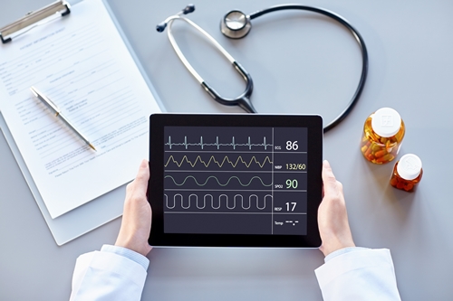 POV Female doctor holding digital tablet with heart monitor
