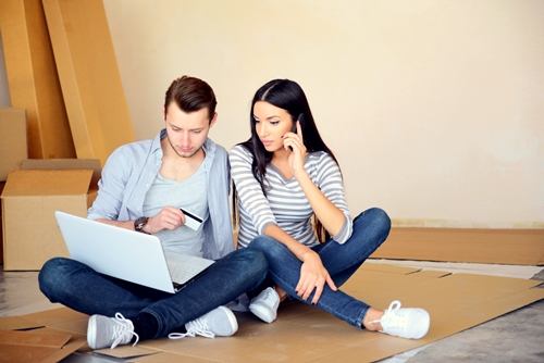 young couple in a new apartment with boxes for moving