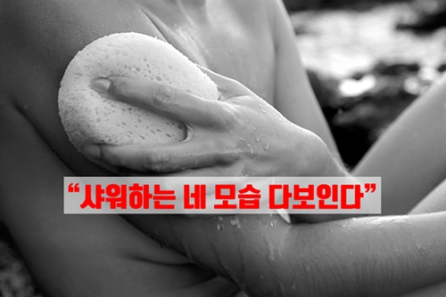 Close-up side view of a nude woman's hand as she rubs a wet sponge on her arm.