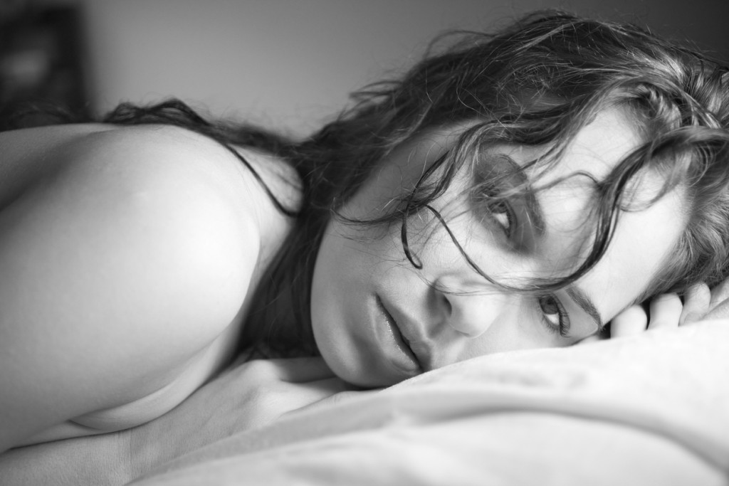 Woman with wet hair lying in bed