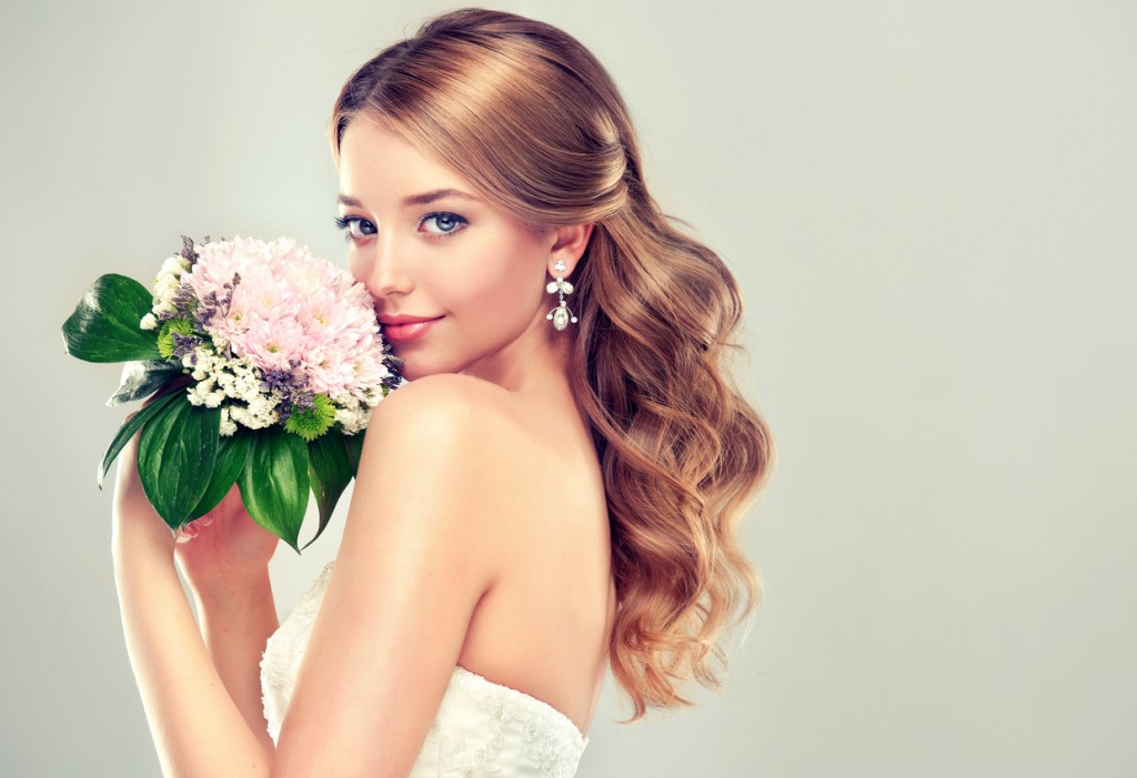 Bride in wedding dress with flower bouquet.