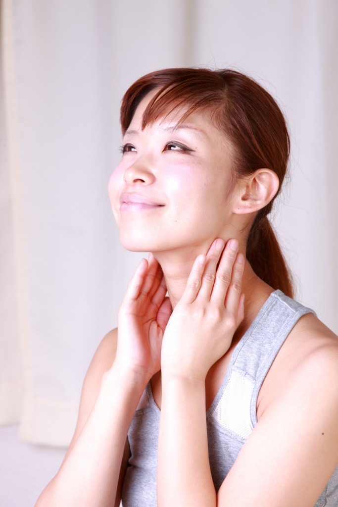 young Japanese woman doing a self neck massage