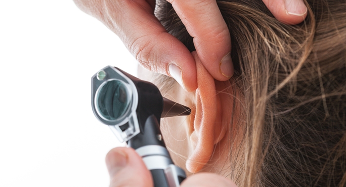 Examining ear with otoscope