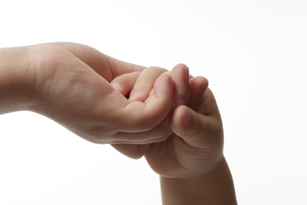 Mother giving hand to a child against white background