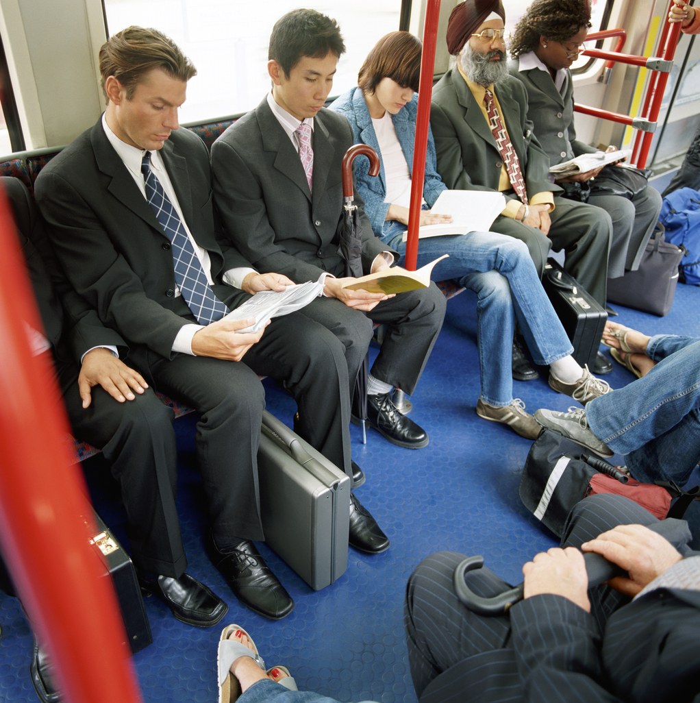 Group of Adults Sit Next to Each Other on a Passenger Train