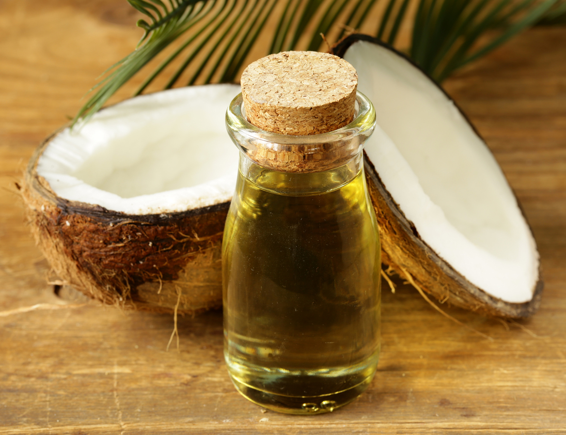 coconut oil in a glass bottle and fresh nuts