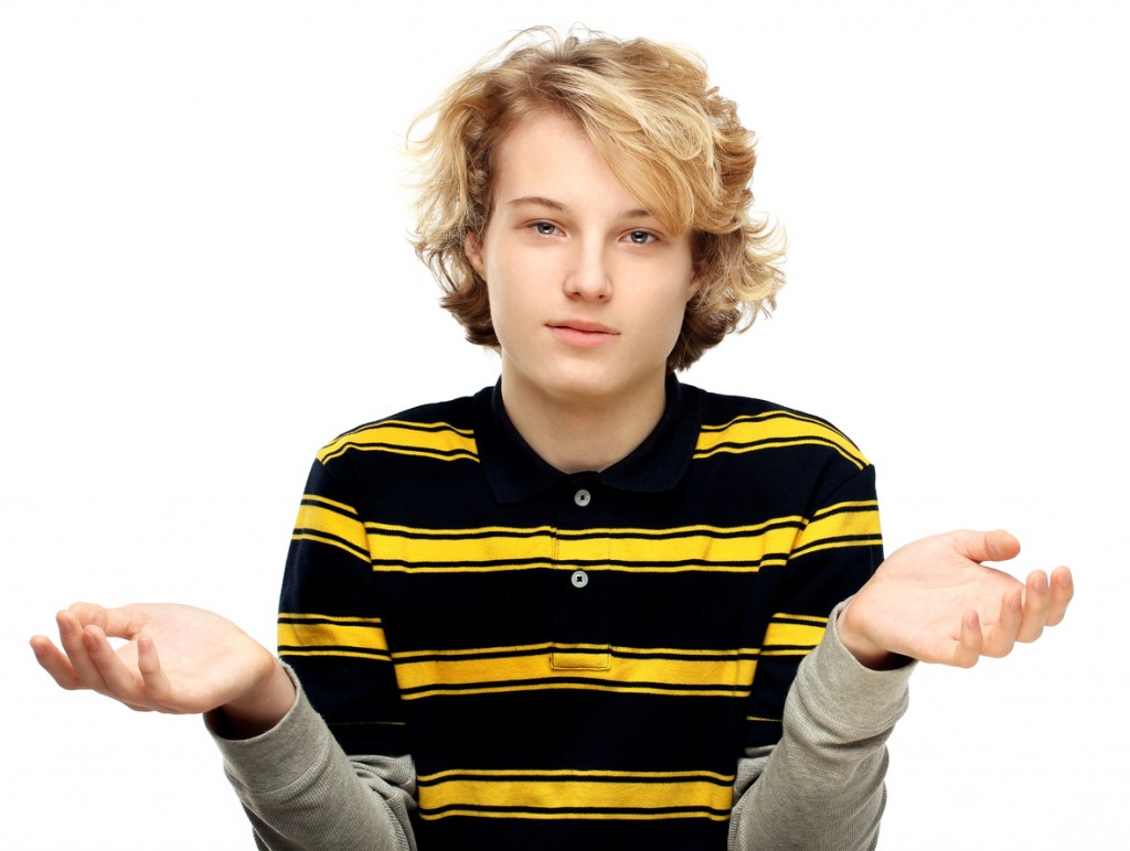 Portrait of  uncertain teenage boy.White background