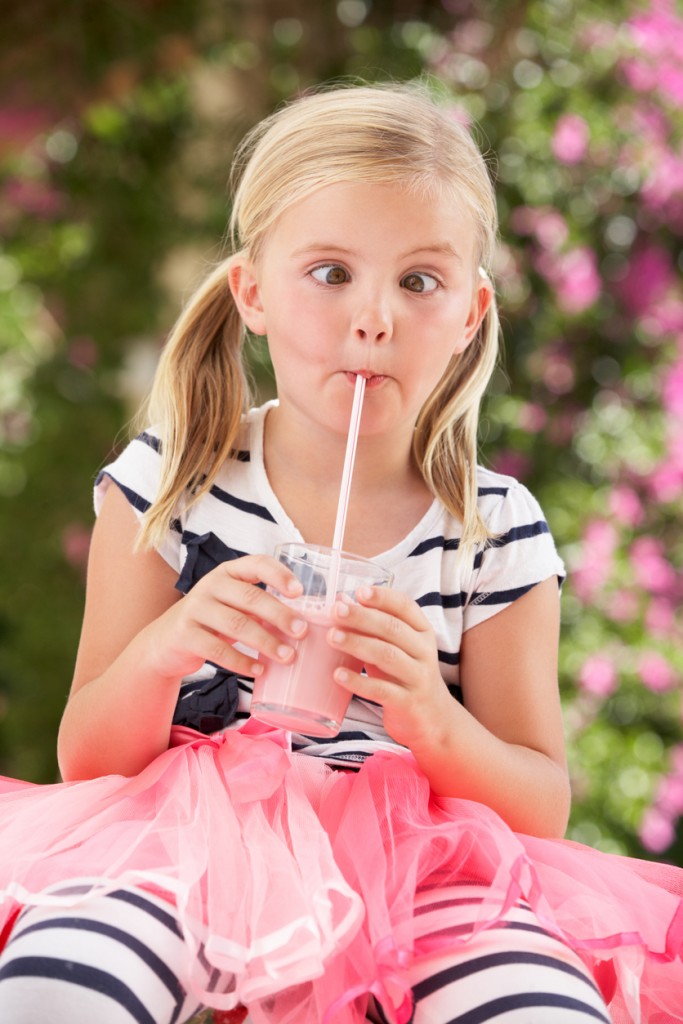 Young Girl Wearing Pink Wellington Boots Drinking Milkshake