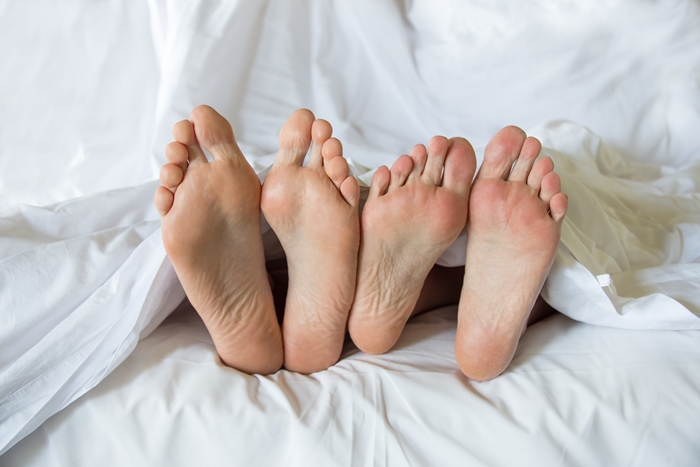 Feet of a couple in a bed