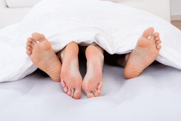 Low Section Of Intimate Couple Under Blanket