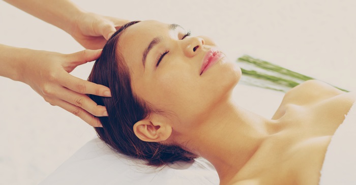A woman receiving a scalp massage