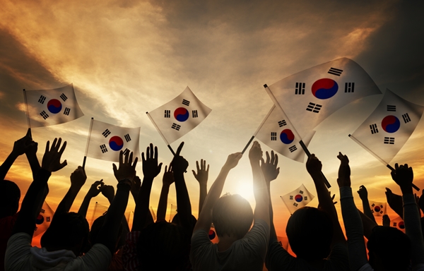 Silhouettes of People Holding Flag of South Korea