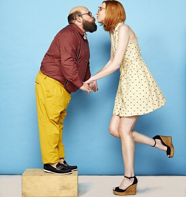 Tall woman and short man kissing