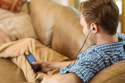 Young man listening to music on his couch