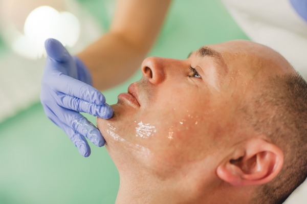Relaxed man having a face massage and a peeling treatment
