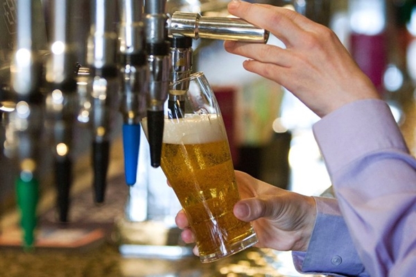 An employee pours a pint of lager at a J.D. Wetherspoon's pu