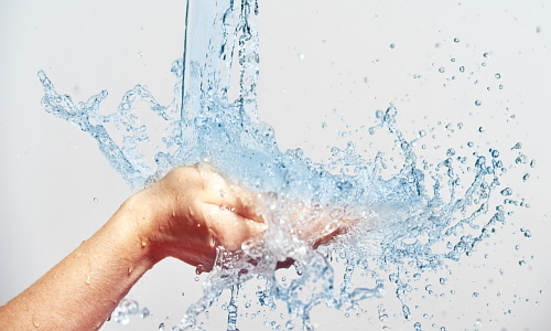 woman hand with water splashes and drops, concept of beauty and skin care