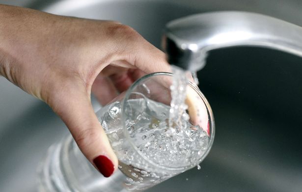 A-woman-fills-up-a-glass-with-water