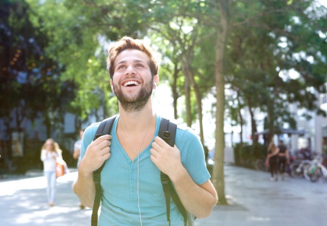 Handsome-young-man-walking-outdoors-with-backpack-640x443