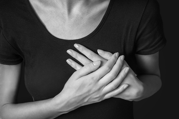 Woman is clutching her chest, heart attack