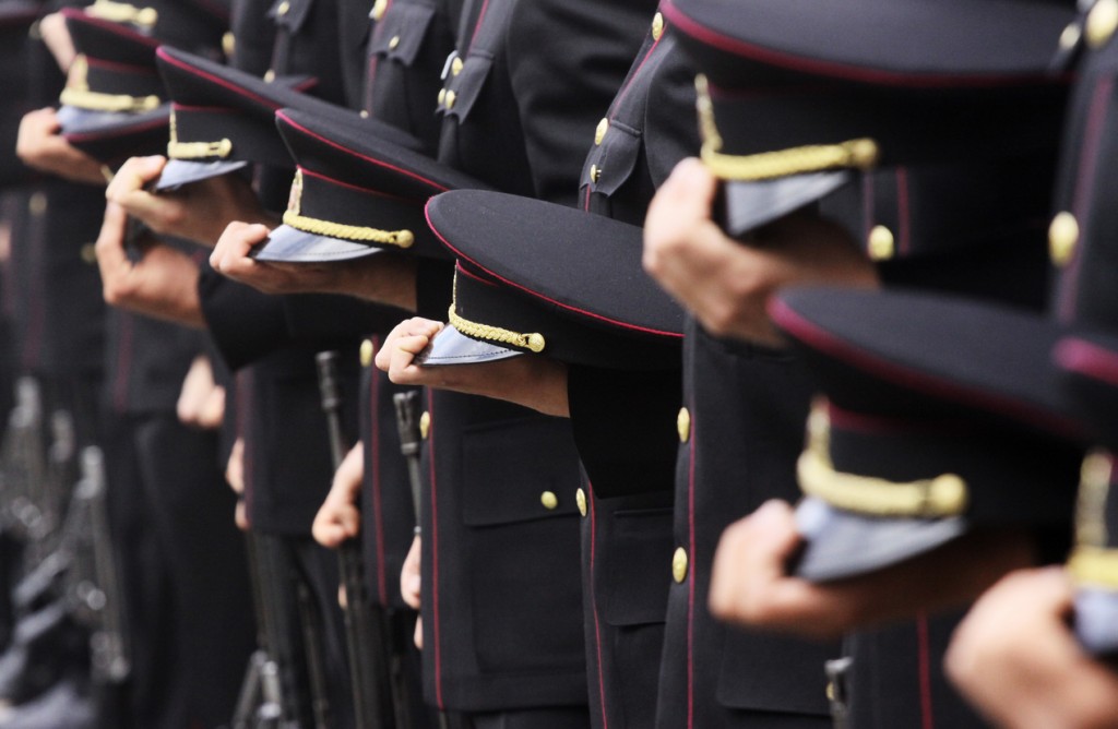 Soldiers standing in line and holding their hats