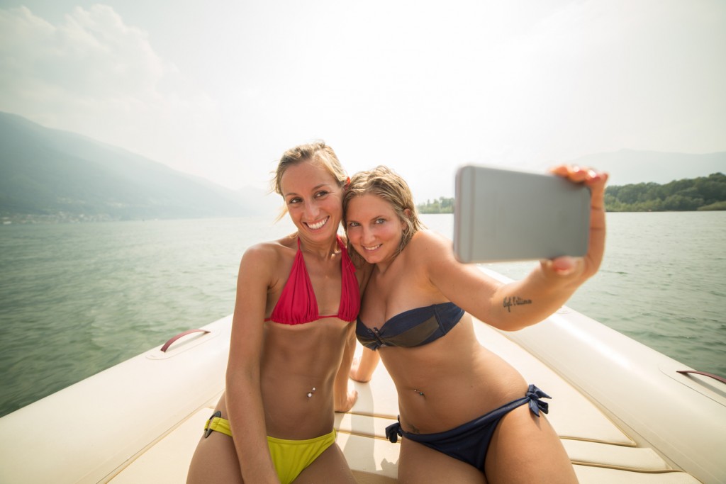 Happy girls taking selfie on boat-Summer