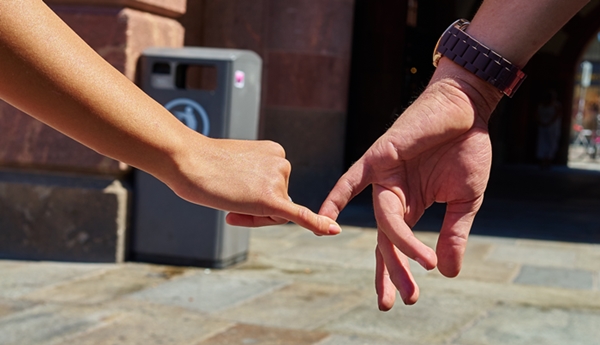 Engaged couple walking in city and holding hands