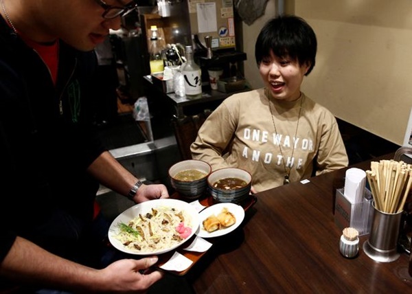 A-waiter-serves-insect-tsukemen-ramen-noodle-to-a-customer-at-Ramen-Nagi-restaurant-in-Tokyo